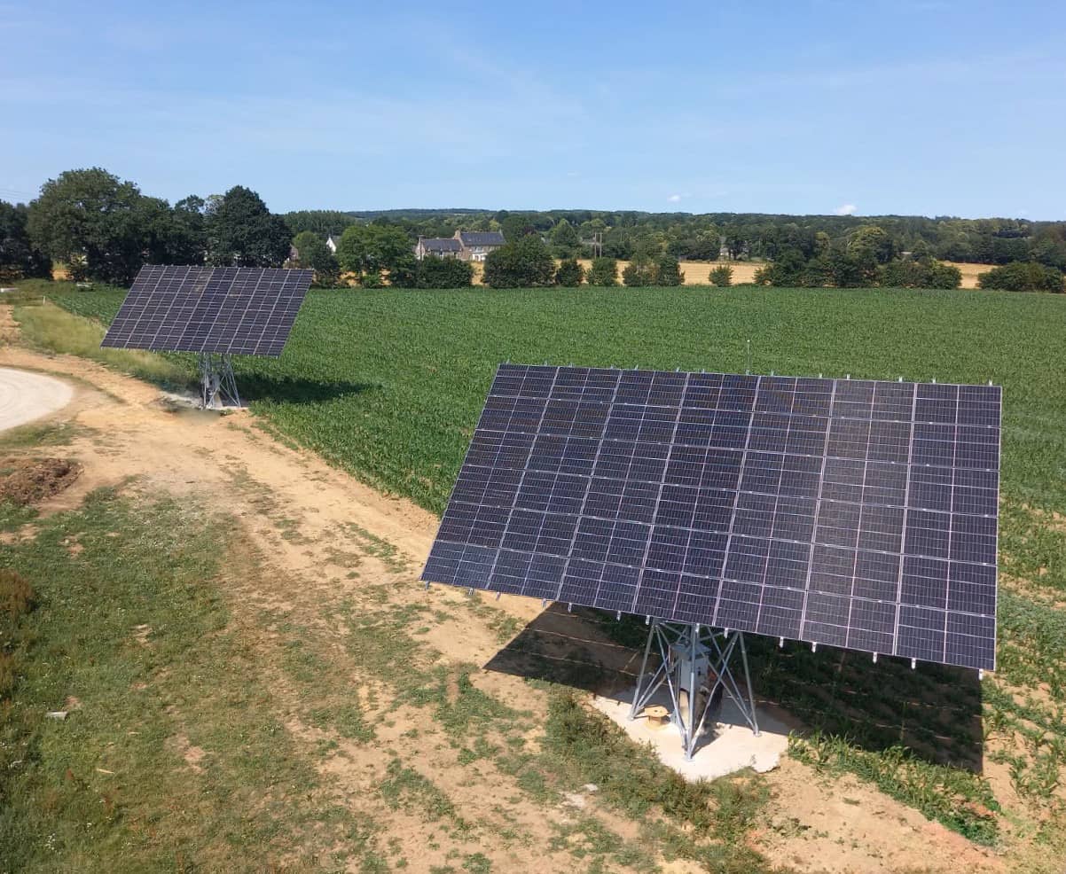 Deux trackers solaires près d'un champ